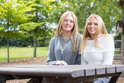 Sisters Casey (left) and Mikaela (right) sit on a bench in the Royal Orthoapedic Hospital garden